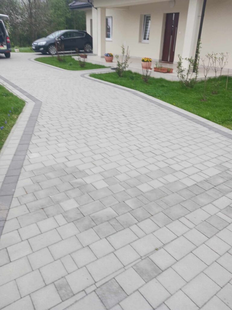 a driveway with cars parked in front of a house