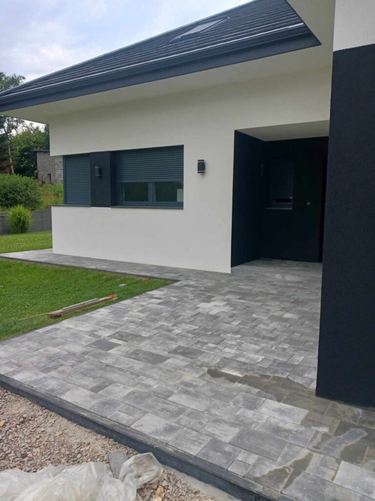 a house with a black door and a brick patio